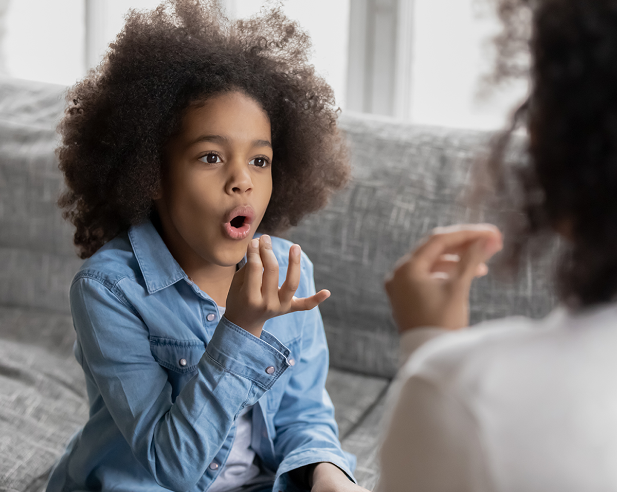 A specially trained speech therapist works closely and compassionately with a child at home. The therapist is engaging the child in speech exercises, using tools and techniques designed to improve communication skills in a nurturing and supportive environment.