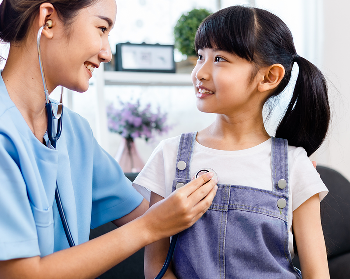 A highly skilled and compassionate nurse uses a stethoscope to check a child's heartbeat at home. This scene reflects the attentive and caring environment provided by At Home Healthcare, emphasizing personal and professional in-home nursing care.